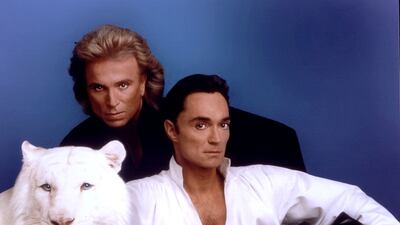 World-renowned illusionists and conservationists Siegfried & Roy pose with their white tiger in this undated photo. The Las Vegas entertainers, honored as Magicians of the Century, perform at The Mirage where they have been the longest and most successful entertainers in the history of Las Vegas. (Photo courtesy of Siegfried & Roy/The Mirage via Getty Images)